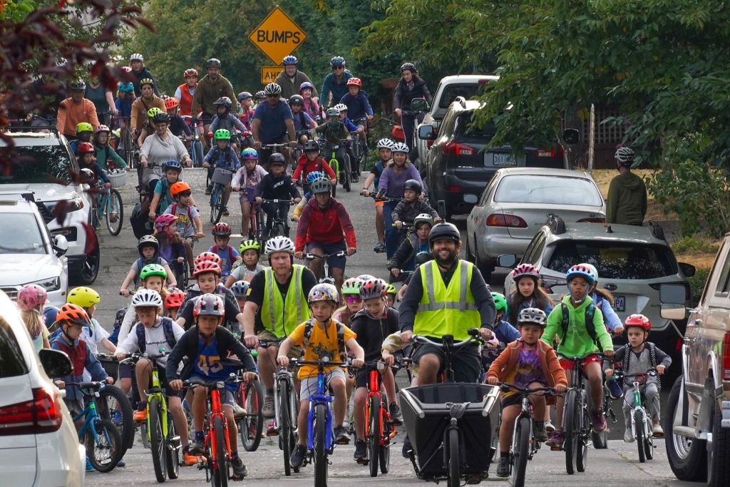 photo of Sam Balto leading a large group of cyclists down a street