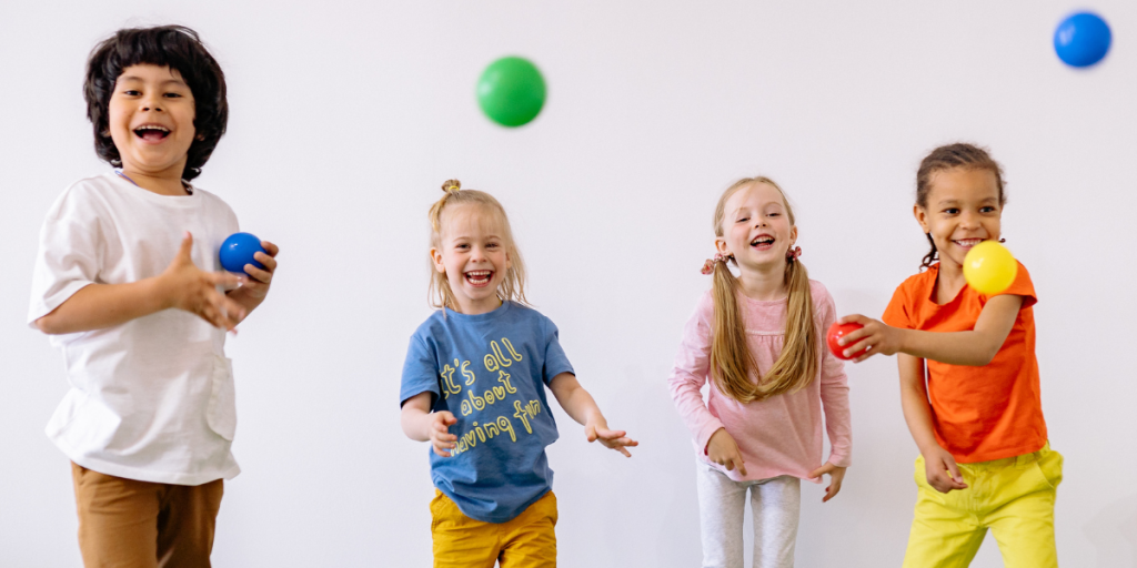 Kids throw colorful balls forward and feel happy.