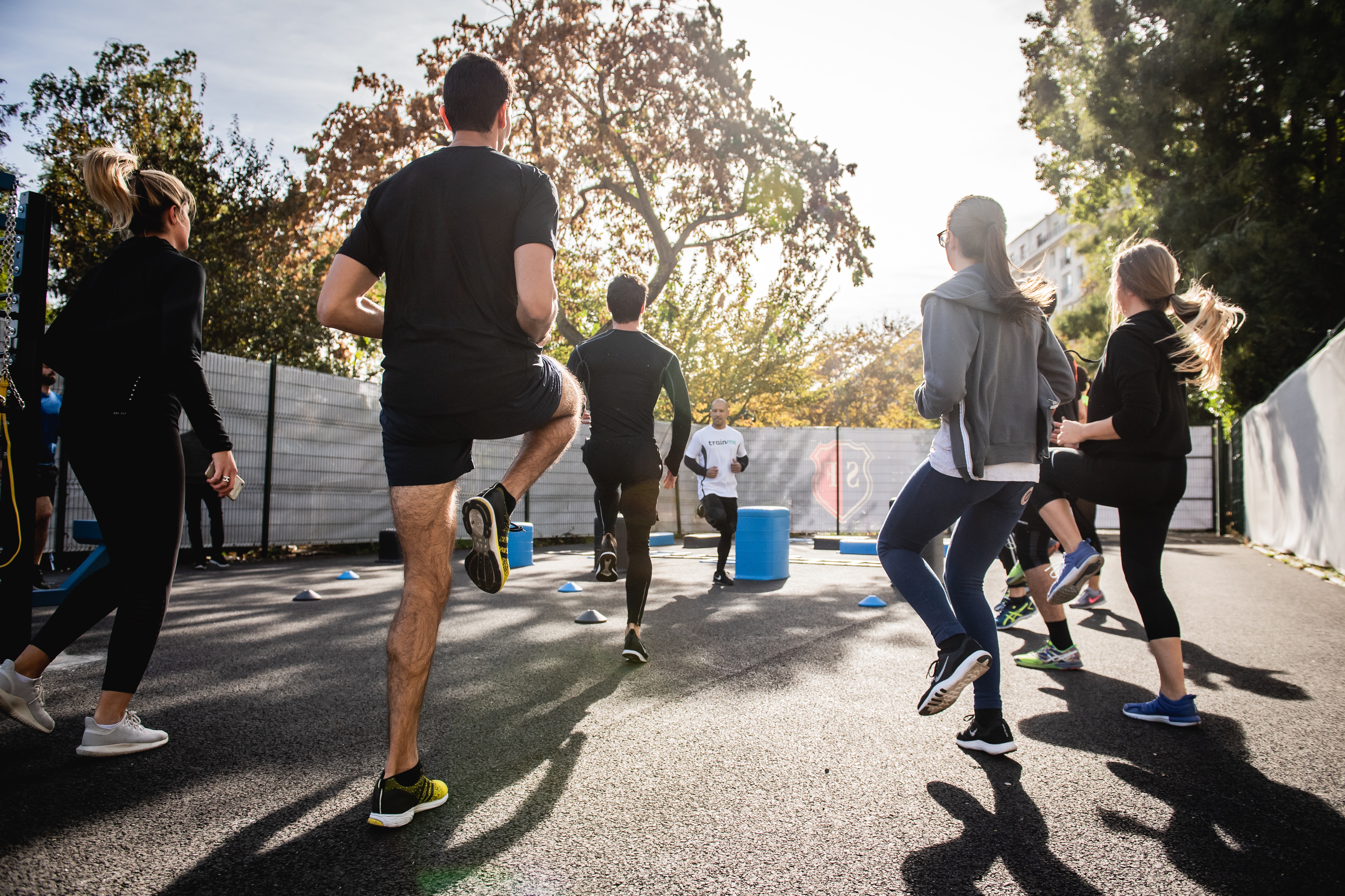 a physical education teacher leading a warm up - the students are jogging on the spot outside