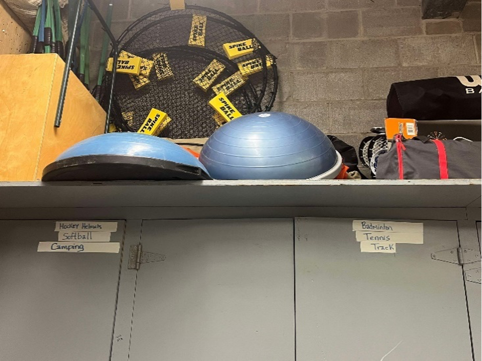 The photo is showing a storage room that has spikeball and bosu ball in it.