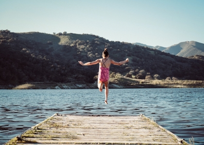 Une fille saute dans un lac