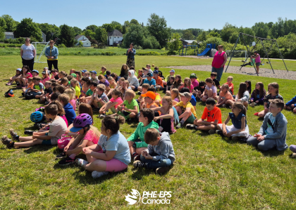 A group of kid sitting in the grass