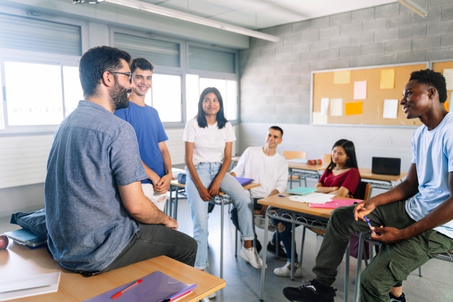 5 élèves devant leur professeur dans une salle de classe