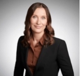 headshot of Jennifer wearing a black blazer and brown collared shirt. 