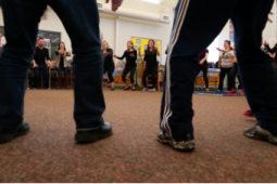 people standing in a circle in a classroom dancing