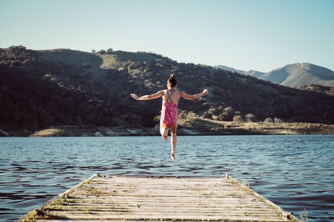 Une fille saute dans un lac