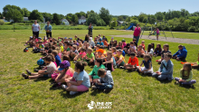 A group of kid sitting in the grass