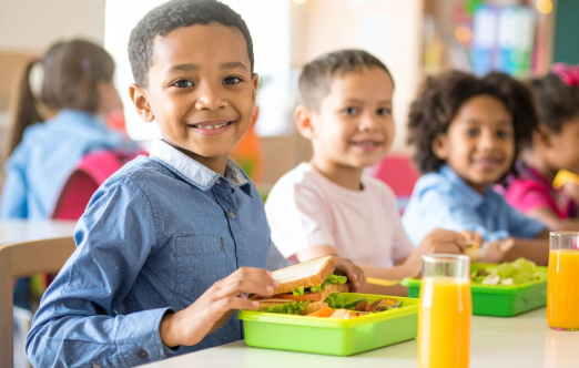Un groupe d'enfants appréciant la nourriture à l'école.