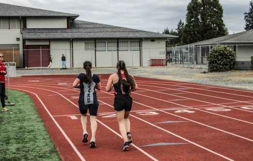 Two youth moving on running track. 